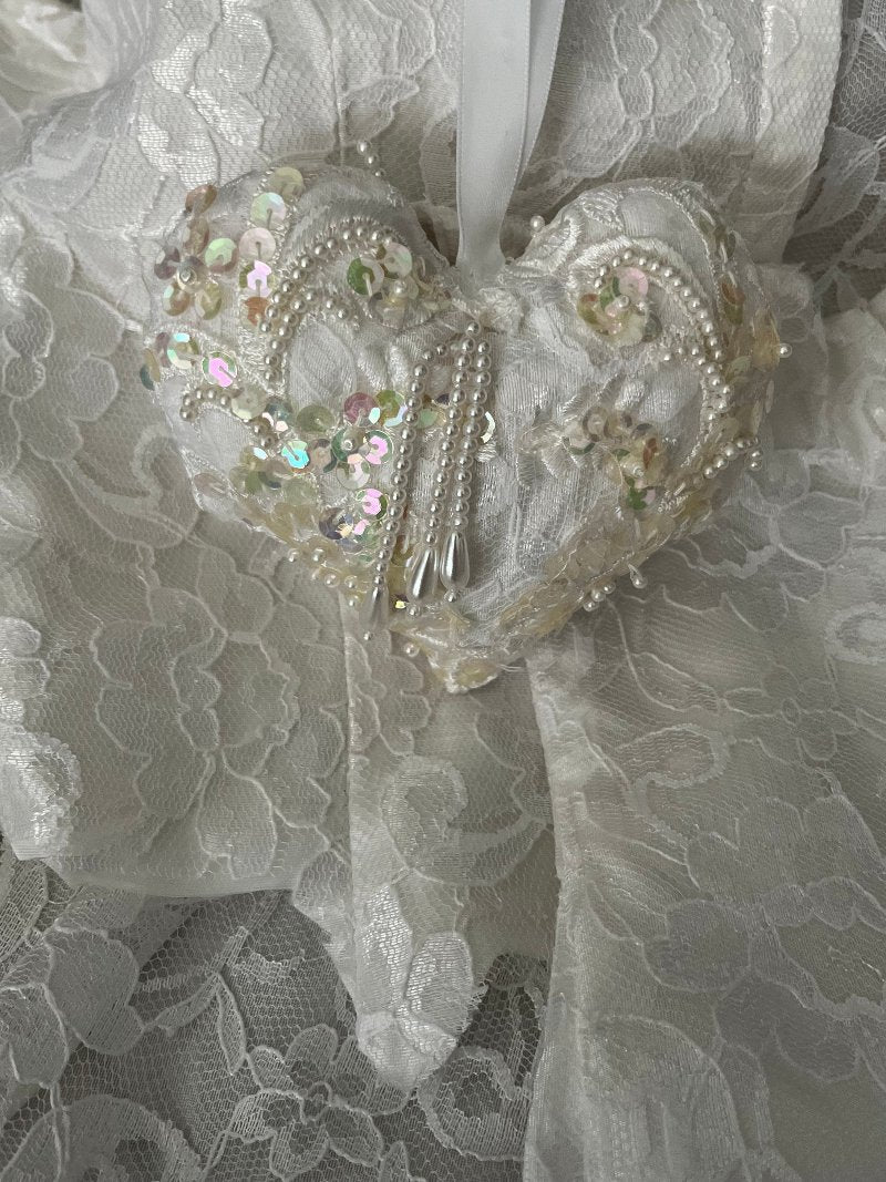 4x4 white keepsake wedding ornament made from repurposed wedding gown. It is covered with sequences and long beads and has a ribbon hanger.