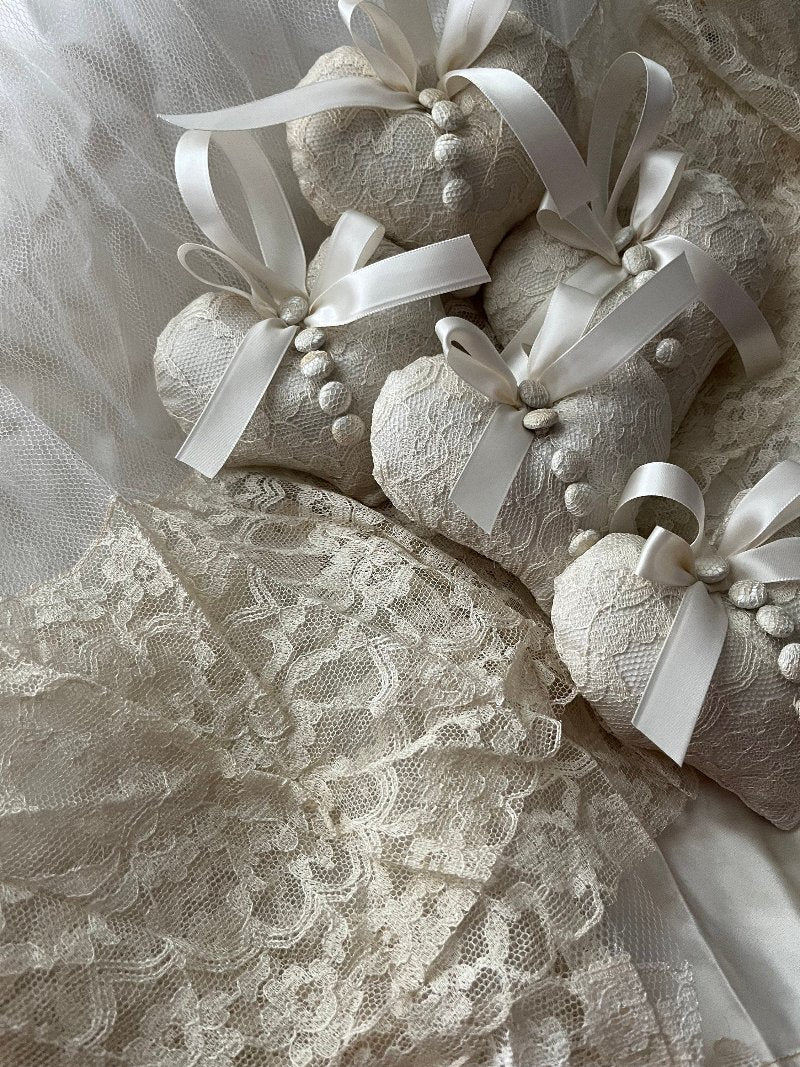 Four 4x4 heart-shaped beige wedding ornament with white embroidered lace made from repurposed wedding gown.  They have a beige ribbon and five lace covered buttons sewn down the front.